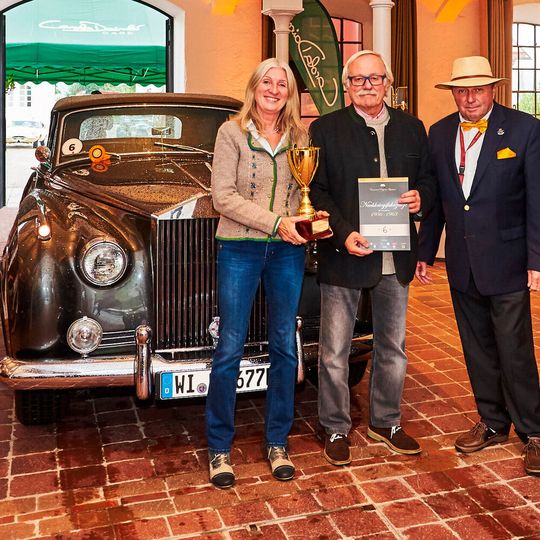 Das Siegerbild: Karl Rolf Muth (Mitte) mit seiner Gattin Ursula sowie Rennlegende und Jurymitglied Jochen Mass. Im Hintergrund das Siegerfahrzeug Rolls-Royce Silver Cloud II von 1962. Das Siegerbild: Karl Rolf Muth (Mitte) mit seiner Gattin Ursula sowie Rennlegende und Jurymitglied Jochen Mass. Im Hintergrund das Siegerfahrzeug Rolls-Royce Silver Cloud II von 1962.