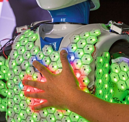 Die Oberfläche des menschengroßen Roboters ist mit einer Vielzahl von Sensoren bedeckt, die auf Annäherung reagieren. Die Oberfläche des menschengroßen Roboters ist mit einer Vielzahl von Sensoren bedeckt, die auf Annäherung reagieren.