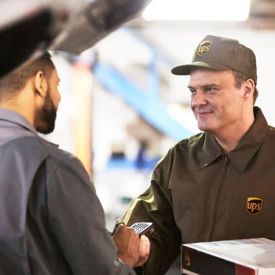 UPS-Zusteller bei der Übergabe einer Sendung. UPS-Zusteller bei der Übergabe einer Sendung.