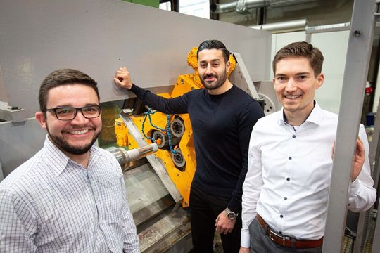 Arbeiten an einem intelligenten Drückwalzprozess: Julian Rozo Vasquez (WPT, Technische Universität Dortmund), Bahman Arian (LUF, Universität Paderborn) und Markus Riepold (Fraunhofer IEM) vor dem Umform-Prüfstand der Universität Paderborn. Arbeiten an einem intelligenten Drückwalzprozess: Julian Rozo Vasquez (WPT, Technische Universität Dortmund), Bahman Arian (LUF, Universität Paderborn) und Markus Riepold (Fraunhofer IEM) vor dem Umform-Prüfstand der Universität Paderborn.