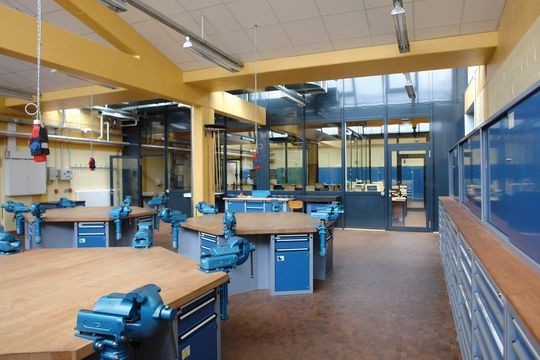 Für das Berufsfeld Metalltechnik wurde dieser Raum mit Sechseck-Werkbänken, höhenverstellbaren Schraubstöcken und einer Energieversorgung von oben eingerichtet. Für das Berufsfeld Metalltechnik wurde dieser Raum mit Sechseck-Werkbänken, höhenverstellbaren Schraubstöcken und einer Energieversorgung von oben eingerichtet.