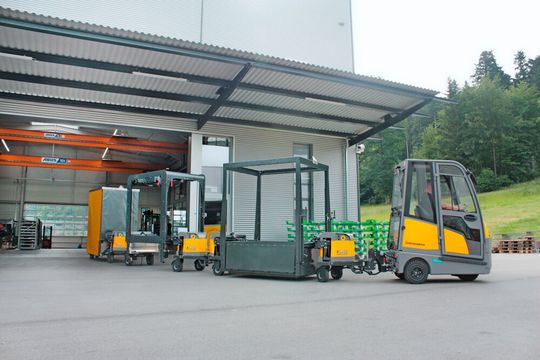 Der Industry-Train-Routenzug Baureihe IT800 mit outdoorfähigen Fahrwerksmodulen und unterschiedlichen Warenträgersystemen, gezogen von einem Jungheinrich-Elektroschlepper EZS 570. Der Industry-Train-Routenzug Baureihe IT800 mit outdoorfähigen Fahrwerksmodulen und unterschiedlichen Warenträgersystemen, gezogen von einem Jungheinrich-Elektroschlepper EZS 570.