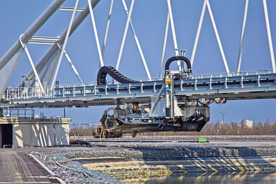 An der um 360° drehbaren Brücke sind zwei bewegliche, selbstständig arbeitende Hochleistungspumpen befestigt, die über rund 140 m mit einer maximalen Geschwindigkeit von 15 m/min mit einer Energiekette verfahren werden.