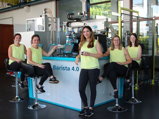 Barista la Vista: Der Fakuma-Ausfall hält auch Dr. BOY nicht davon ab, Neues zu präsentieren. Hier werden mithilfe eines 7-Achs-Roboters individualisierte Kaffeebecher auf einer BOY 125 E gespritzt. Barista la Vista: Der Fakuma-Ausfall hält auch Dr. BOY nicht davon ab, Neues zu präsentieren. Hier werden mithilfe eines 7-Achs-Roboters individualisierte Kaffeebecher auf einer BOY 125 E gespritzt.