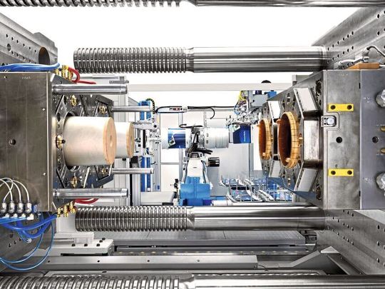 Krauss-Maffei hat mit der GX 1300 eine schlagkräftige Spritzgießmaschine für den Verpackungsbereich entwickelt. Blick in den Arbeitbereich, wo ein Werkzeug für große Kunststoffeimer mit IML-Deko installiert ist. Krauss-Maffei hat mit der GX 1300 eine schlagkräftige Spritzgießmaschine für den Verpackungsbereich entwickelt. Blick in den Arbeitbereich, wo ein Werkzeug für große Kunststoffeimer mit IML-Deko installiert ist.
