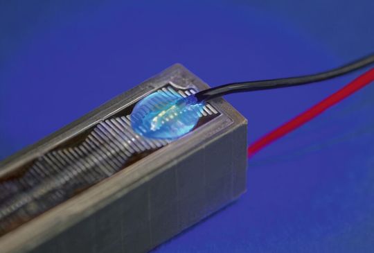 Fluoreszenzprüfung einer mit Vitralit UD 8052 F geschützten Litze auf einem Piezoaktor. Fluoreszenzprüfung einer mit Vitralit UD 8052 F geschützten Litze auf einem Piezoaktor.
