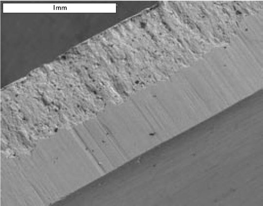 Mikroskopaufnahme einer gestanzten Blechkante mit Grat.