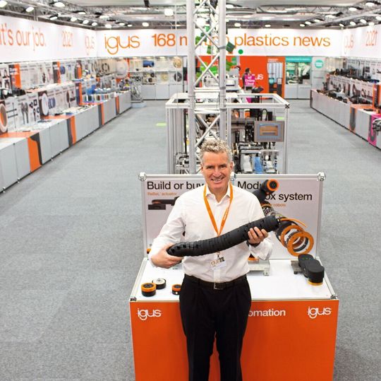 Geschäftsführer Frank Blase zeigt die TRX Roboter-Energiezuführung auf dem komplett erneuerten physisch-virtuellen Messestand von Igus in Köln, der gerade mit dem «iF Communication Design Award 2021» prämiert wurde. Geschäftsführer Frank Blase zeigt die TRX Roboter-Energiezuführung auf dem komplett erneuerten physisch-virtuellen Messestand von Igus in Köln, der gerade mit dem «iF Communication Design Award 2021» prämiert wurde.