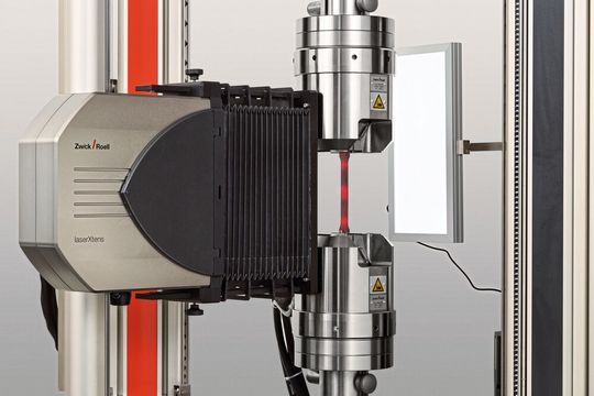 Während der Dehnungsmessung mit dem Laser X Tens wird die Probe durch hydraulische Probenhalter gehalten. Während der Dehnungsmessung mit dem Laser X Tens wird die Probe durch hydraulische Probenhalter gehalten.