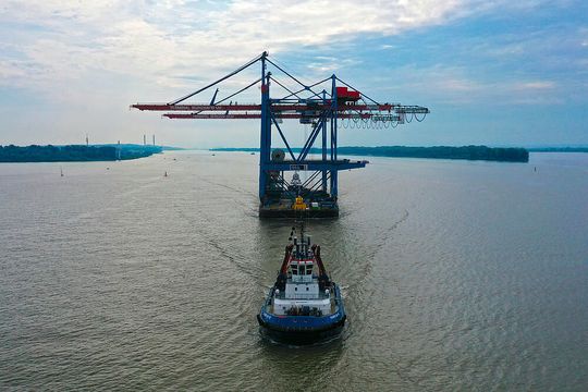Die Aufnahme zeigt den Schleppverband mit den beiden für Estland bestimmten Ship-to-Shore-Kranen, wie er sich die Elbe hinunter auf den Weg macht.