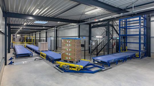 In der Fördertechnik von Schne-frost in Löningen leiten Schwenkstationen mit einem außermittig angeordneten Drehpunkt die Paletten um 90 Grad „um die Ecke“. Die Schwenkstation fährt bündig bis vor das Gliederband. In der Fördertechnik von Schne-frost in Löningen leiten Schwenkstationen mit einem außermittig angeordneten Drehpunkt die Paletten um 90 Grad „um die Ecke“. Die Schwenkstation fährt bündig bis vor das Gliederband.