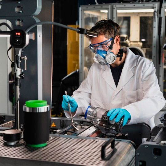 Das trockene Ausgangsmaterialgemisch wird in den Kalanderspalt der Drytraec-Anlage gegeben. Das trockene Ausgangsmaterialgemisch wird in den Kalanderspalt der Drytraec-Anlage gegeben.