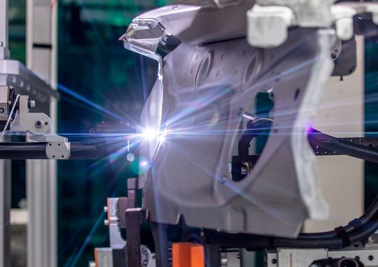 Die Audi AG bevorzugt bei der partiellen Oberflächenreinigung dünner Karosserieteile aus Aluminium das Plasmaverfahren Acerios von Fronius. Hier hat ein Roboter bei Audi ein Bauteil an den fest installierten Plasmabrenner laviert, wo es nun für das Bolzenschweißen vorbehandelt wird. Die Audi AG bevorzugt bei der partiellen Oberflächenreinigung dünner Karosserieteile aus Aluminium das Plasmaverfahren Acerios von Fronius. Hier hat ein Roboter bei Audi ein Bauteil an den fest installierten Plasmabrenner laviert, wo es nun für das Bolzenschweißen vorbehandelt wird.