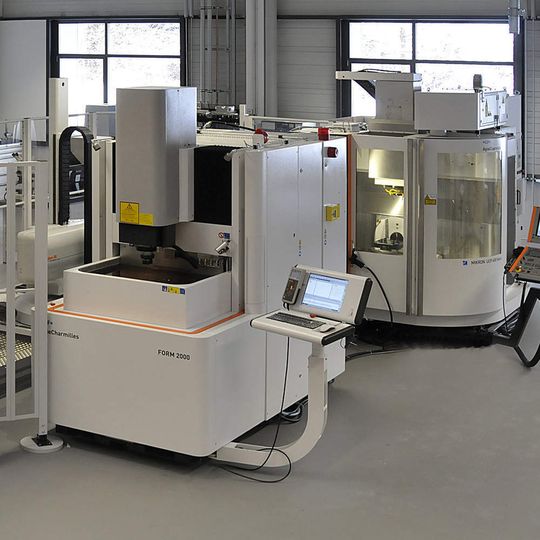 Bild 1: Linearzelle mit Roboter verkettet eine Senkerodiermaschine Form 2000 und ein Bearbeitungszentrum Mikron UCP 600 Vario. Bilder: Agie Charmilles Bild 1: Linearzelle mit Roboter verkettet eine Senkerodiermaschine Form 2000 und ein Bearbeitungszentrum Mikron UCP 600 Vario. Bilder: Agie Charmilles