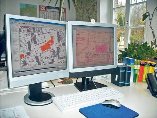Auf dem einen Monitor sieht man die Katasterkarte mit der Kirche in der Mitte, auf dem zweiten Monitor sieht man den sogenannten Riss zur Vermessung der Kirche Auf dem einen Monitor sieht man die Katasterkarte mit der Kirche in der Mitte, auf dem zweiten Monitor sieht man den sogenannten Riss zur Vermessung der Kirche