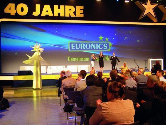 Zum Abschluss der Eröffnungsveranstaltung lässt Euronics-Vorstand Benedict Kober Moderatorin Barbara Schöneberger Blumen überreichen. Zum Abschluss der Eröffnungsveranstaltung lässt Euronics-Vorstand Benedict Kober Moderatorin Barbara Schöneberger Blumen überreichen.
