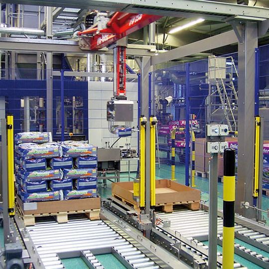 Bild 1 (links): Die Roboterpalettieranlage nimmt inklusive Zu- und Abführung eine Fläche von 16 m² in Anspruch. Bild 1 (links): Die Roboterpalettieranlage nimmt inklusive Zu- und Abführung eine Fläche von 16 m² in Anspruch.
