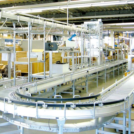 Dem Packbereich wird über oben liegende Fördertechnik und anschließendem Senkrechtförderer die kommissionierte Ware zugeführt.Bild: Förster & Krause Dem Packbereich wird über oben liegende Fördertechnik und anschließendem Senkrechtförderer die kommissionierte Ware zugeführt.Bild: Förster & Krause