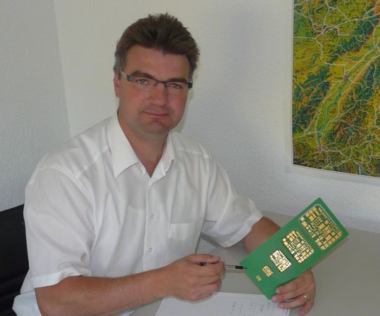 Sven Nehrdich, Geschäftsführer der Jenaer Leiterplatten GmbH, mit der stufenweise vergrößerten Leiterplatte für den Lokdekoder Sven Nehrdich, Geschäftsführer der Jenaer Leiterplatten GmbH, mit der stufenweise vergrößerten Leiterplatte für den Lokdekoder