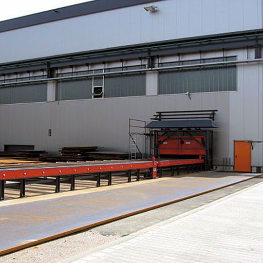 Um den logistischen Aufwand bei der Beschickung der Anlage zu minimieren, wurden 20 m der für eine Heavy-Duty-Belastung bis 3000 kg/lfm ausgelegten Rollenbahn durch ein Rolltor in den Außenbereich geführt. Bild: Rösler Um den logistischen Aufwand bei der Beschickung der Anlage zu minimieren, wurden 20 m der für eine Heavy-Duty-Belastung bis 3000 kg/lfm ausgelegten Rollenbahn durch ein Rolltor in den Außenbereich geführt. Bild: Rösler