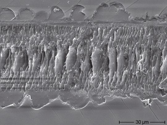 Sand und Staub-Test an Abdeckgläsern: REM-Inspektion eines Kratzers in der Oberflächenvergütung, der bis ins Glassubstrat reicht