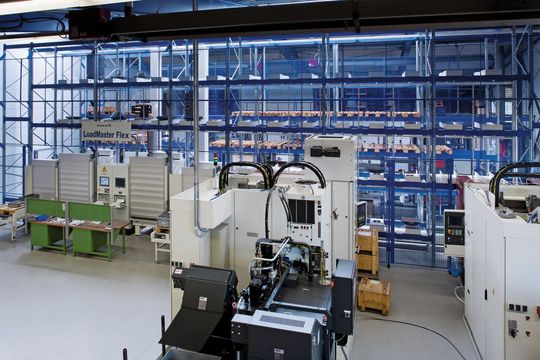 Bild 1: Das flexible Ladesystem mit Rohmaterialbehältern und Maschinenpaletten verkettet zwei Bearbeitungszentren. (Bild: Schuler)