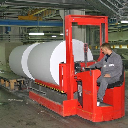 Der Papierrollen-Transporter nimmt Material, das unterschiedliche Durchmesser hat, mit einer Prismengabel auf. Bild: Genkinger-Hubtex Der Papierrollen-Transporter nimmt Material, das unterschiedliche Durchmesser hat, mit einer Prismengabel auf. Bild: Genkinger-Hubtex