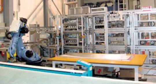 Die Anlage fertigt aus trockenen Kohlenstofffaserlagen drei unterschiedliche Einzelpreforms. Diese Vorformlinge werden vom Roboter zu einem kompletten Preform für die Harzinjektion komplettiert. (Bild: Brötje-Automation)