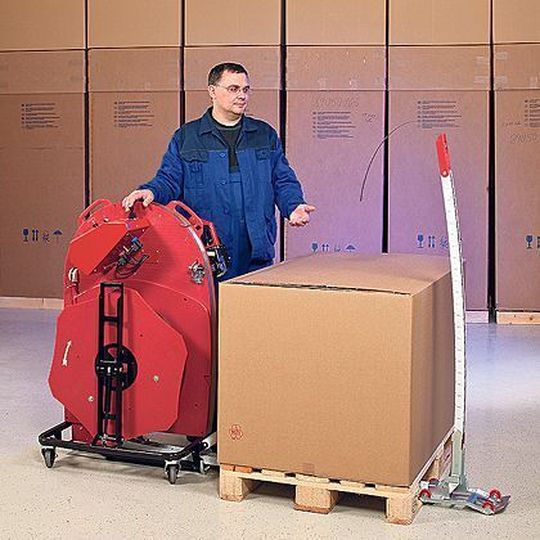 Das Umreifungssystem wird vor die Palette gerollt. Die Kettenlanze schiebt sich dann unter das Packgut, nimmt das Band mit und führt es dem Bediener wieder zu. Bild: Ergopack Das Umreifungssystem wird vor die Palette gerollt. Die Kettenlanze schiebt sich dann unter das Packgut, nimmt das Band mit und führt es dem Bediener wieder zu. Bild: Ergopack