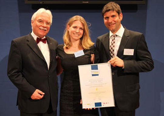Dr. Wolfgang M. Kaerkes (Deutsche Gesellschaft für Qualität e.V.), Deborah Leib (Projektmanagerin) und Christian Walther (DELO Industrie Klebstoffe) bei der Übergabe der Auszeichnung. (Bild: Delo)