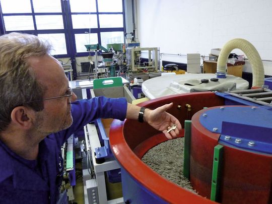 Sichtprüfung der Schlüssel, die in der Gleitschleifanlage entgratet werden. (Bild: Wieland+Oertli)