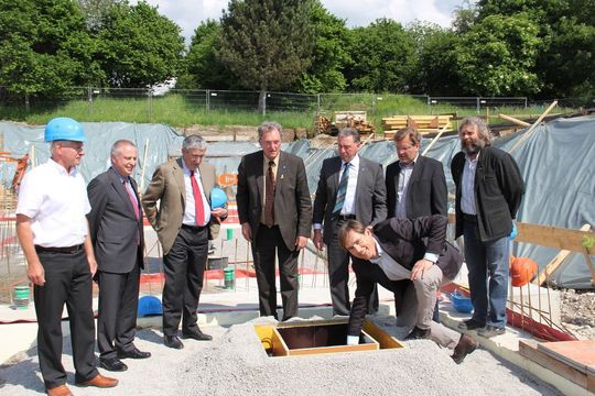 Die Grundsteinlegung: Georg Böck (Bauunternehmung Böck), Dr. Angelo Schmandra (BHS), Dr. Christof Kemmann (BHS), Landrat Gebhard Kaiser, Bürgermeister Hubert Buhl, Stadtbaumeister Lutz-Holger Behre, Betriebsratsvorsitzender Engelbert Bechteler (von links), Architekt Martin Unzeitig (kniend) (Bild: BHS-Sonthofen) Die Grundsteinlegung: Georg Böck (Bauunternehmung Böck), Dr. Angelo Schmandra (BHS), Dr. Christof Kemmann (BHS), Landrat Gebhard Kaiser, Bürgermeister Hubert Buhl, Stadtbaumeister Lutz-Holger Behre, Betriebsratsvorsitzender Engelbert Bechteler (von links), Architekt Martin Unzeitig (kniend) (Bild: BHS-Sonthofen)