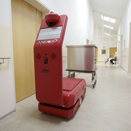Das fahrerlose Transportfahrzeug (FTF) Casero nimmt einen Wäschebehälter auf. Bild: MLR System Das fahrerlose Transportfahrzeug (FTF) Casero nimmt einen Wäschebehälter auf. Bild: MLR System