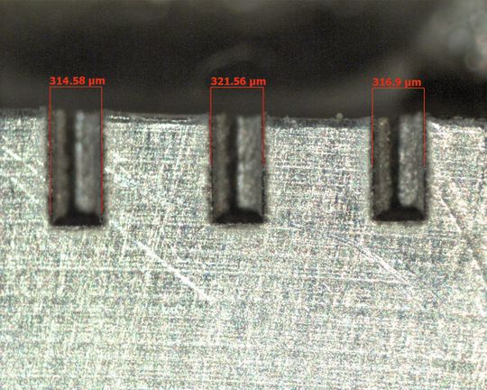 Bild 1: Schliffbild von Nuten als Beispiel einer mikrotiefen Bearbeitung mit einem Faserlaser: Die Nuten wurden in vierzig Ebenen überlagert bearbeitet. (Bild: Verfasser) Bild 1: Schliffbild von Nuten als Beispiel einer mikrotiefen Bearbeitung mit einem Faserlaser: Die Nuten wurden in vierzig Ebenen überlagert bearbeitet. (Bild: Verfasser)