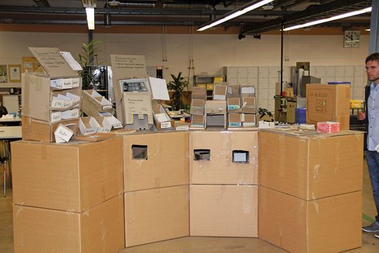 Der Prototyp eines Arbeitsplatzes wird mit Pappkartons nachgestellt und so lange verbessert, bis er dem natürlichen Bewegungsfluss der Beschäftigten gerecht wird. (Bild: Otto)
