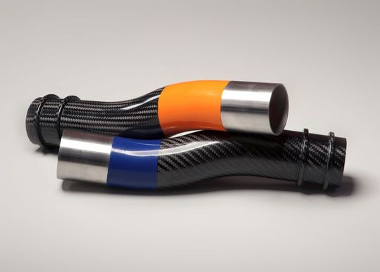 Die Integration elastomerer Bereiche in CFK-Strukturen kompensiert Nachteile, die aus der hohen Steifigkeit des Faserverbundkunststoffs entstehen. Ein Beispiel dafür ist dieser Luftführungskanal mit elastomerem Mittelstück. (Bild: Wimmer Carbontechnik) Die Integration elastomerer Bereiche in CFK-Strukturen kompensiert Nachteile, die aus der hohen Steifigkeit des Faserverbundkunststoffs entstehen. Ein Beispiel dafür ist dieser Luftführungskanal mit elastomerem Mittelstück. (Bild: Wimmer Carbontechnik)