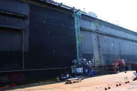 Das Trägersystem mit dem Applikator des Fraunhofer-IFAM im Trockendock der Emder Werft und Dockbetriebe GmbH. (Bild: Fraunhofer-IFAM) Das Trägersystem mit dem Applikator des Fraunhofer-IFAM im Trockendock der Emder Werft und Dockbetriebe GmbH. (Bild: Fraunhofer-IFAM)