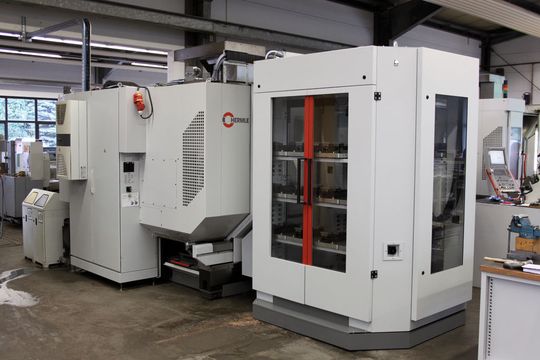 Bild 1: Die Übergabeposition des Werkstück- und Paletten-Handhabungssystems befindet sich mittig vor dem CNC-Bearbeitungszentrum. (Bild: Hermle) Bild 1: Die Übergabeposition des Werkstück- und Paletten-Handhabungssystems befindet sich mittig vor dem CNC-Bearbeitungszentrum. (Bild: Hermle)