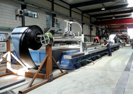 Für das Handling von tonnenschweren Eimerbagger-Fördergurten baute Aquatec zwei massive handbetätigte Haspeln. Damit wurden die Matten abschnittsweise vom Coil abgewickelt, mit den nötigen Schnitten versehen und anschliessend wieder aufgehaspelt. (Aquatec) Für das Handling von tonnenschweren Eimerbagger-Fördergurten baute Aquatec zwei massive handbetätigte Haspeln. Damit wurden die Matten abschnittsweise vom Coil abgewickelt, mit den nötigen Schnitten versehen und anschliessend wieder aufgehaspelt. (Aquatec)