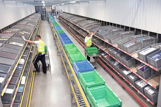 Bei TJ Morris werden die Mitarbeiter in der Kommissionierzone ständig mit leeren Behältern versorgt und kommissionieren mehrfache Aufträge per Pick by Voice. (Bild: SSI Schäfer) Bei TJ Morris werden die Mitarbeiter in der Kommissionierzone ständig mit leeren Behältern versorgt und kommissionieren mehrfache Aufträge per Pick by Voice. (Bild: SSI Schäfer)