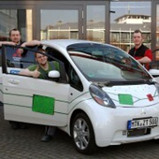 Die drei Azubis sind stolz auf das neu lackierte Elektroauto. (Foto: Spies Hecker)