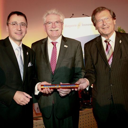 Ein neues Gesicht bei Bayern Innovativ: Prof. Dr. Werner Klaffke (links), neuer Geschäftsführer der Gesellschaft des Feistaats Bayern, bekommt den symbolischen Stab aus den Händen seines Vorgängers Prof. Dr.-Ing. Josef Nassauer (rechts) und Bayerns Wirtschaftsminister Martin Zeil überreicht. Ein neues Gesicht bei Bayern Innovativ: Prof. Dr. Werner Klaffke (links), neuer Geschäftsführer der Gesellschaft des Feistaats Bayern, bekommt den symbolischen Stab aus den Händen seines Vorgängers Prof. Dr.-Ing. Josef Nassauer (rechts) und Bayerns Wirtschaftsminister Martin Zeil überreicht.