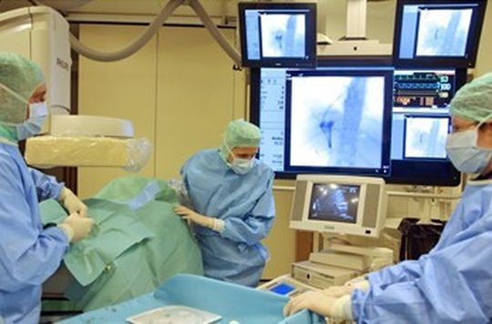 Ärzteteam bei einer Stent-Implantation (Behandlung von Gefäßen mit kleinen Gefäßstützen) Ärzteteam bei einer Stent-Implantation (Behandlung von Gefäßen mit kleinen Gefäßstützen)