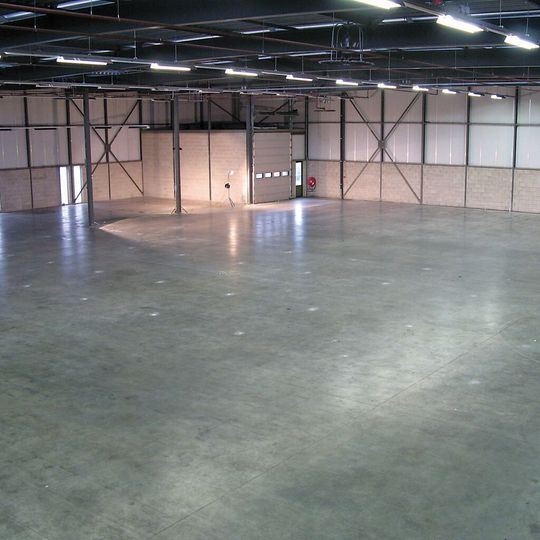 Nach einer erfolgreichen Sanierung ist der Betonboden einer Industrie- oder Logistikhalle wieder glatt und belastbar. Nach einer erfolgreichen Sanierung ist der Betonboden einer Industrie- oder Logistikhalle wieder glatt und belastbar.