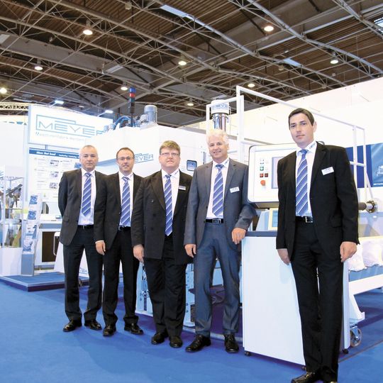 Markteinführung der Anlage Die Maschinenfabrik Herbert Meyer GmbH hat eine Anlage entwickelt, die den Kleber als Pulver hochpräzise aufträgt und so aufschmilzt, dass sich Tröpfchen in definierter Form bilden. Auf der JEC 2012 wurde die Entwicklung am Markt eingeführt (v.l.n.r): Uwe Ringel (Vertrieb und Projektierung), Thomas Meyer (Geschäftsführer), Jean-Georges Leininger, Georg Voggenreiter (beide Vertrieb und Projektierung), Stephan Bierl (Anwendungstechnik). Markteinführung der Anlage Die Maschinenfabrik Herbert Meyer GmbH hat eine Anlage entwickelt, die den Kleber als Pulver hochpräzise aufträgt und so aufschmilzt, dass sich Tröpfchen in definierter Form bilden. Auf der JEC 2012 wurde die Entwicklung am Markt eingeführt (v.l.n.r): Uwe Ringel (Vertrieb und Projektierung), Thomas Meyer (Geschäftsführer), Jean-Georges Leininger, Georg Voggenreiter (beide Vertrieb und Projektierung), Stephan Bierl (Anwendungstechnik).