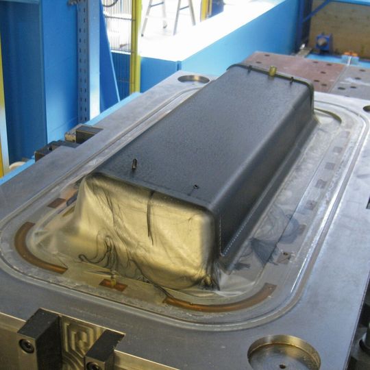 Von der Harzinjektion in die vorgeheizte, evakuierte Form bis zum Entformen des CFK-Bauteils ist nur eine Minute vergangen – ohne Faserverzug. Der Aushärtung folgt die mechanische Bauteilbearbeitung.