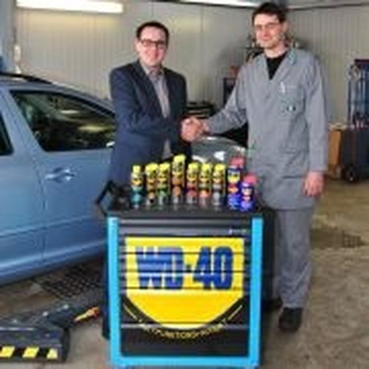 Lars Lüdemann (li.) von WD-40 überreicht Michael Schoß (re.) den Hauptgewinn des Gewinnspiels von WD-40 und »kfz-betrieb«.