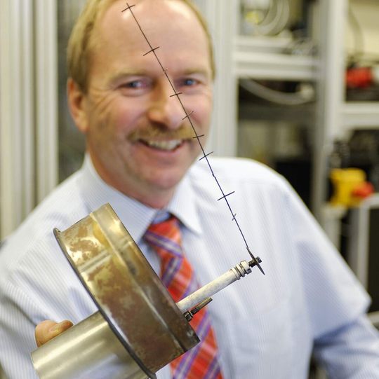 Dietmar Steiner von Bosch zeigt die von ihm erfundene Schnappelektrode. Wird der feine Draht unter Hochspannung gesetzt, holt er mehr als 85 % Feinstaub aus der Abluft von Kaminöfen. Die Elektrode ist an einer Metallscheibe befestigt, die sich beim Aufheizen und Abkühlen schlagartig verformt. So wird der gesammelte Staub wunschgemäß abgeschüttelt. Die große metallene Halterung hält die Elektrode im Abgasrohr. Dietmar Steiner von Bosch zeigt die von ihm erfundene Schnappelektrode. Wird der feine Draht unter Hochspannung gesetzt, holt er mehr als 85 % Feinstaub aus der Abluft von Kaminöfen. Die Elektrode ist an einer Metallscheibe befestigt, die sich beim Aufheizen und Abkühlen schlagartig verformt. So wird der gesammelte Staub wunschgemäß abgeschüttelt. Die große metallene Halterung hält die Elektrode im Abgasrohr.