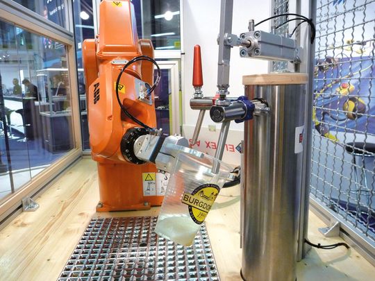 Der Roboter hält den leeren Becher unter den Zapfhahn mit der gewünschten Biersorte und der Füllvorgang beginnt. Für den Personen- und Anlagenschutz sorgt eine komplette Sicherheitslösung von ABB. Der Roboter hält den leeren Becher unter den Zapfhahn mit der gewünschten Biersorte und der Füllvorgang beginnt. Für den Personen- und Anlagenschutz sorgt eine komplette Sicherheitslösung von ABB.