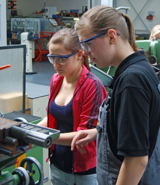Isabel Stein, Auszubildende zur Zerspanungsmechanikerin bei Weidmüller, zeigt Girls’ Day -Teilnehmerin Laura Badura den richtigen Umgang mit einer Fräsmaschine.